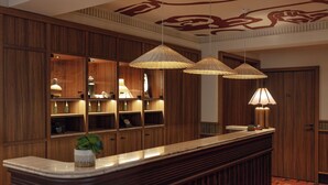 A reception area with wooden paneling, a marble counter, and three hanging lamps. - SALVIA Paris (Paris)