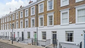 A row of terraced houses with white window frames and brick facades. - New stylish 3-Bed Pimlico House near Big Ben (London)