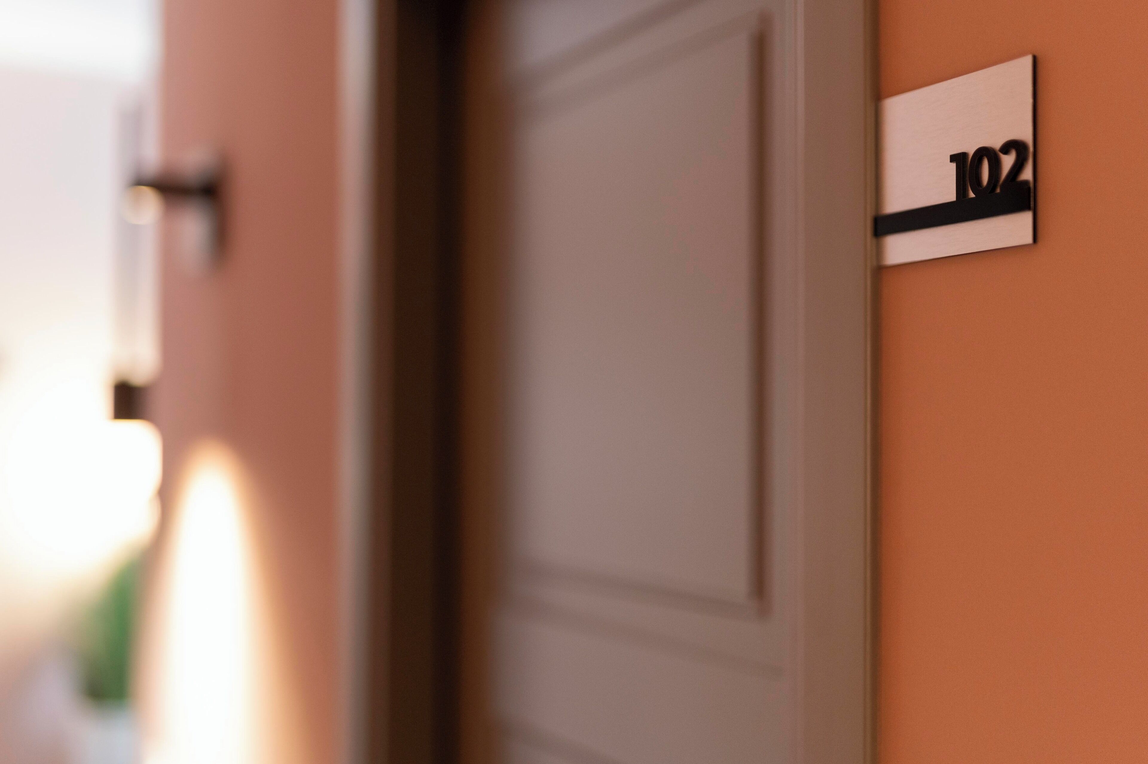 A close-up of a door with a sign indicating room number 102.