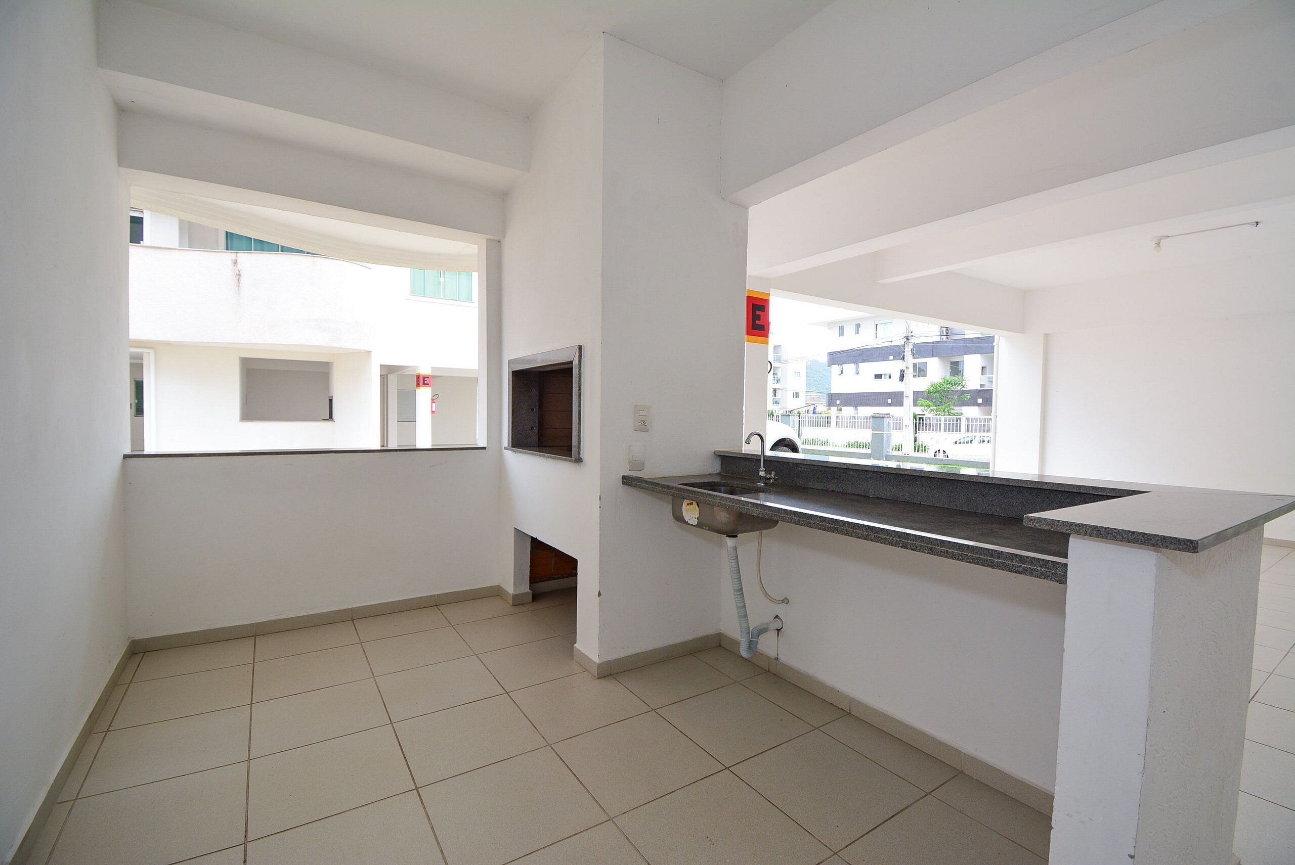 A kitchen with a built-in sink, a window, and a view of a building outside.