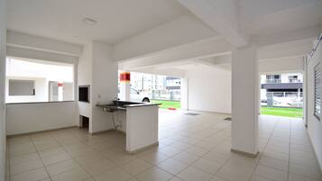 A spacious, well-lit interior with a kitchen area, large windows, and a view of the outside.