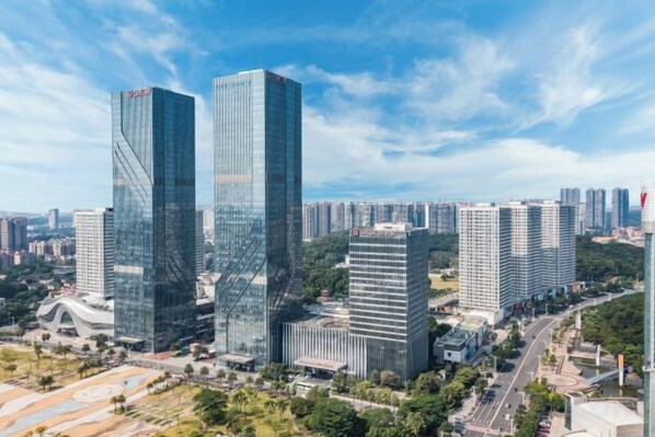A high-rise building complex with multiple skyscrapers, surrounded by greenery and other buildings.