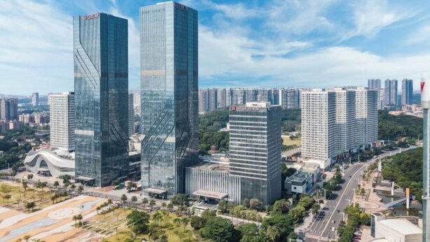 Stadsgezicht met moderne wolkenkrabbers, waaronder twee opvallende gebouwen met glazen gevels.