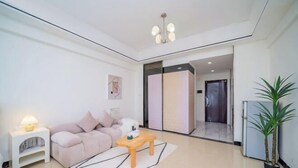 Een moderne woonkamer met een bank, een salontafel, een lamp en een plant.