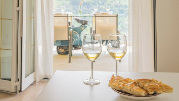 Une table à manger avec deux verres à vin et une assiette de pain.