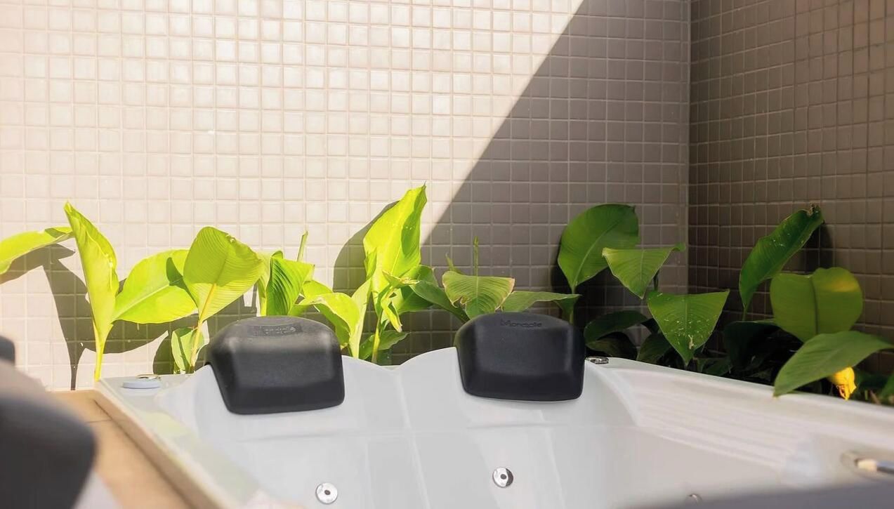 A spa area with a tiled wall and a hot tub.