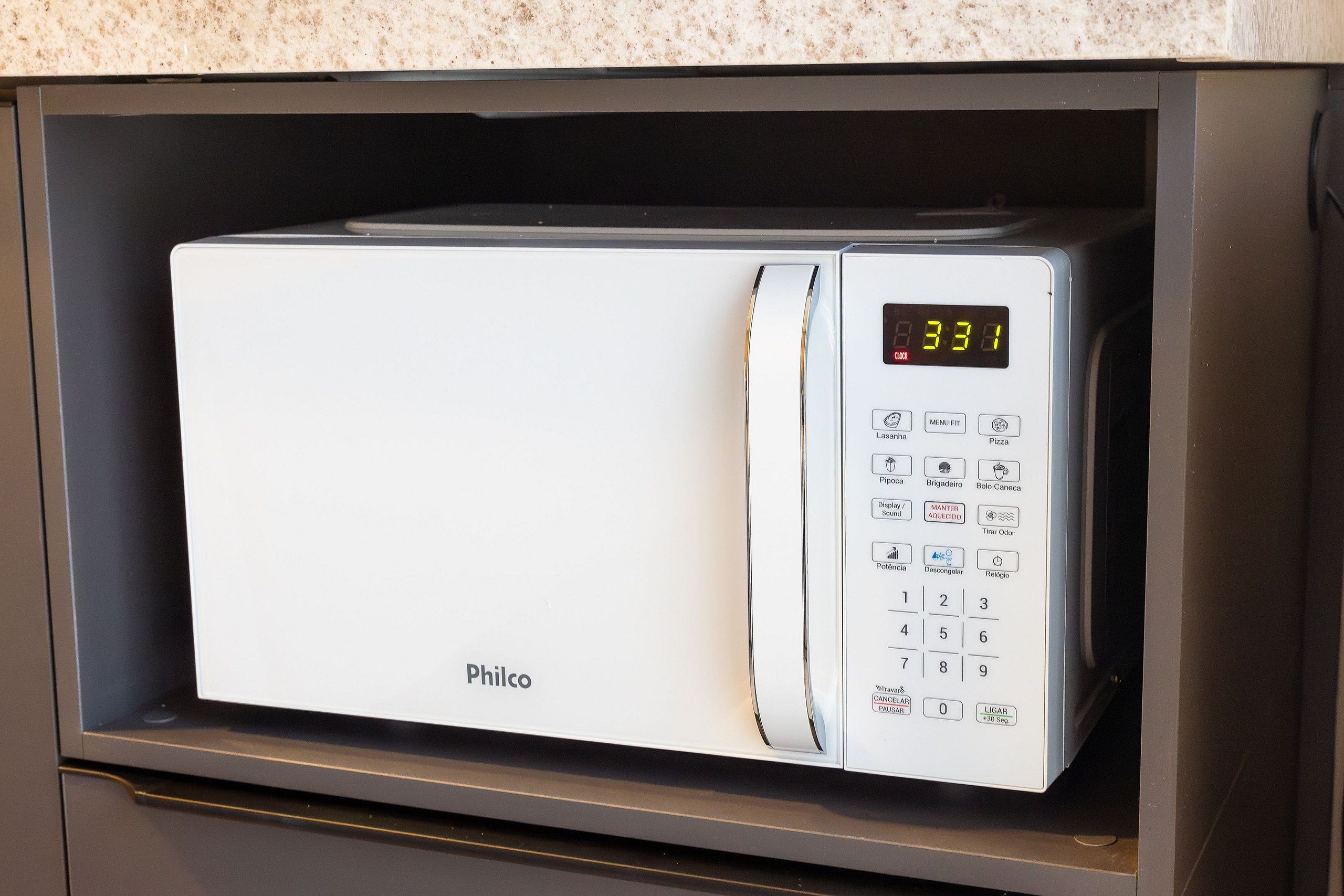 A white microwave with a digital clock displaying 3:31, a menu button, and a brand name 'Philco' on the front.