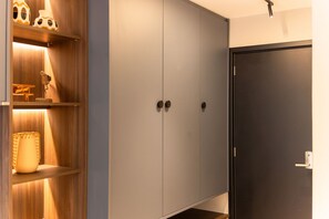 Un armario con dos puertas, un estante con objetos decorativos y una puerta con manija.