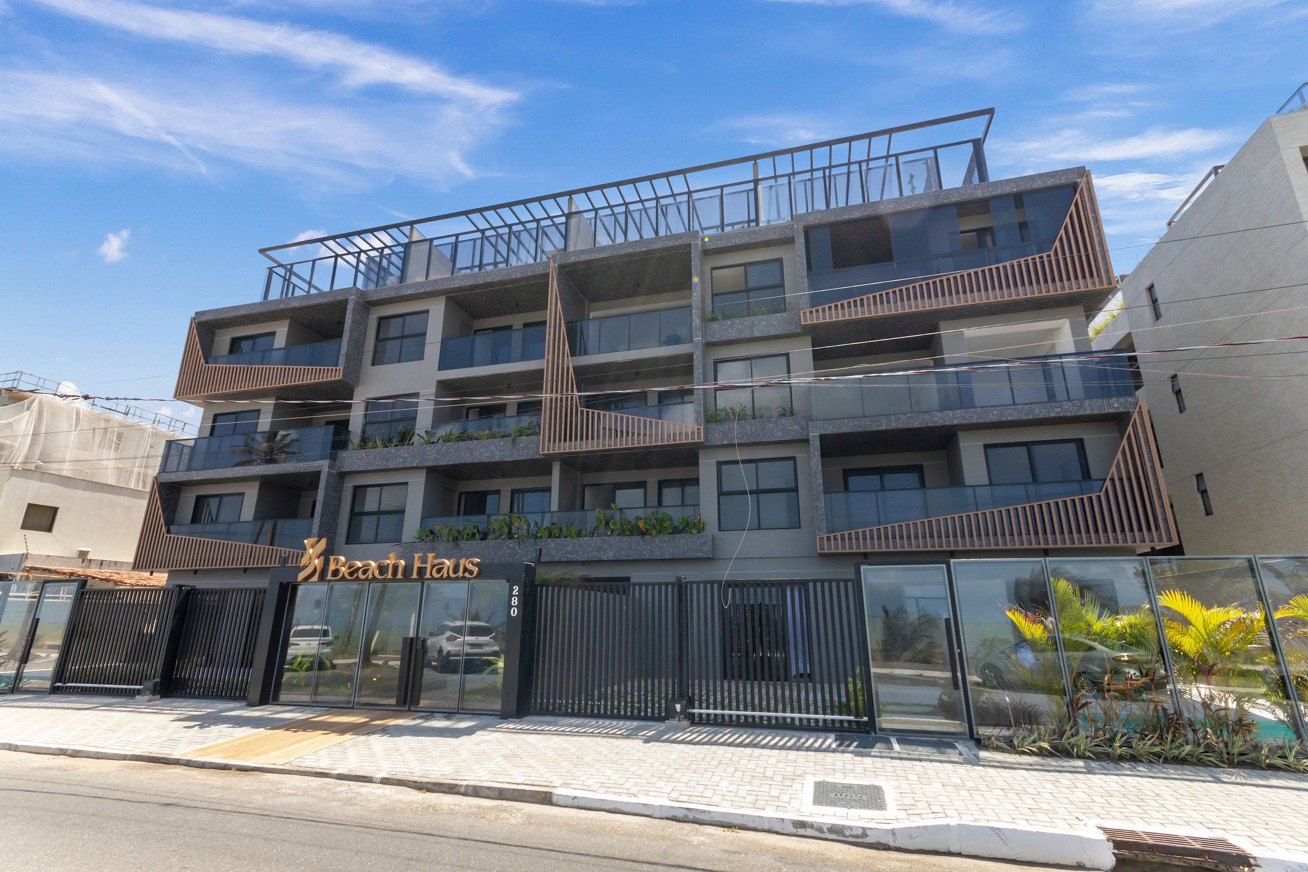 A multi-story hotel with balconies, a glass facade, and a sign reading 'Beach Haus.'