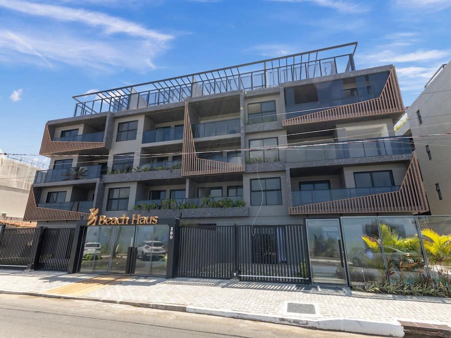 A multi-story hotel with balconies, a glass facade, and a sign reading 'Beach Haus.'