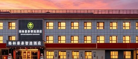 A hotel with a modern facade, multiple windows, and a prominent sign.