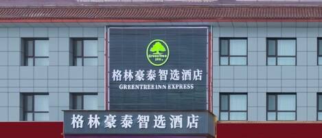 Un hotel con un letrero llamativo del Greentree Inn Express.
