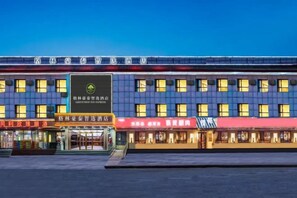 Un hôtel à plusieurs étages, avec une enseigne bien visible au centre.