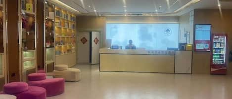 Zona de recepción con escritorio, estanterías y asientos.