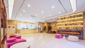 A modern hotel lobby with a reception desk, seating area, and a fireplace. - GreenTree Inn Express Hotel (Beijing Fangshan District Government Longhu Tianjie) (Beijing)
