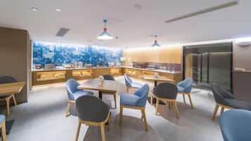 A modern dining area with a central island, seating, and a kitchen in the background.
