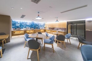 A modern dining area with a central island, seating, and a kitchen in the background. - Homeinn·NEO(Shenyang Tiexi Square Glide Shengjing Hospital Xinghua Metro Station) (Shenyang)