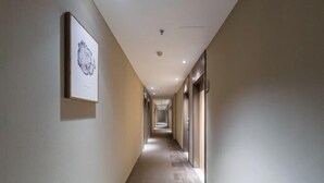 A long, narrow hallway with a patterned carpet and framed artwork on the walls. - Homeinn·NEO(Shenyang Tiexi Square Glide Shengjing Hospital Xinghua Metro Station) (Shenyang)