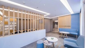 A modern lounge area with seating and a reception desk. - Homeinn·NEO(Shenyang Tiexi Square Glide Shengjing Hospital Xinghua Metro Station) (Shenyang)