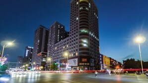 A high-rise building with multiple floors, large windows, and illuminated signage. - Homeinn·NEO(Shenyang Tiexi Square Glide Shengjing Hospital Xinghua Metro Station) (Shenyang)
