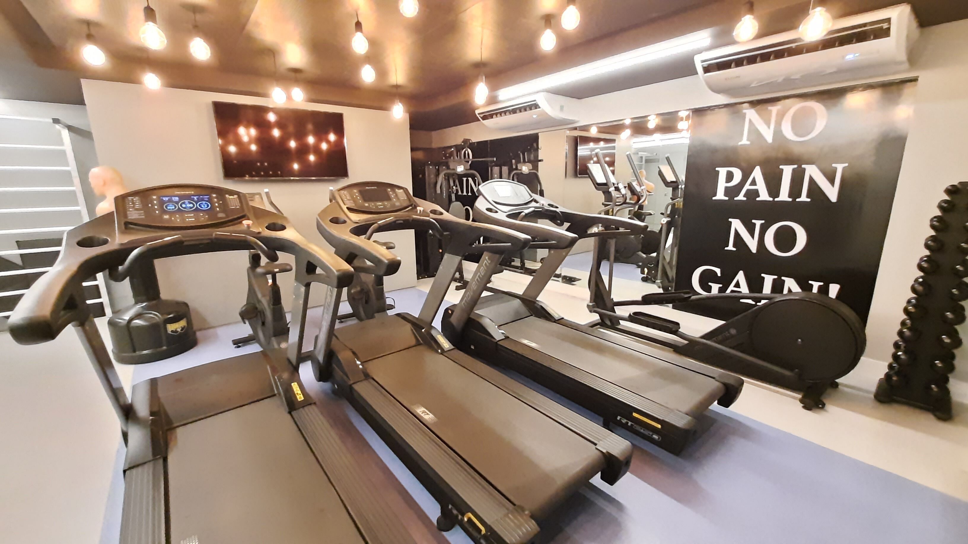 A gym with treadmills, stationary bikes, and a motivational sign.