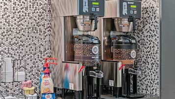 Una estación de café con dos máquinas de café Bunn, un dispensador de Nestlé Coffee Mate y un molinillo de café en grano.