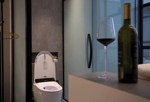 Relax in a sleek bathroom with a toilet, glass shower, and countertop space for unwinding.