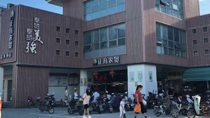 A building with a modern design, featuring vertical wooden panels and large windows. - Yingdong Motel (Shanghai)