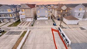 A residential area with houses, a parking lot, and a red line marking.