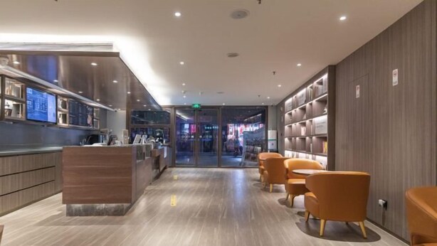 A modern hotel lobby with a reception desk, seating area, and a view into the restaurant. - HanTing Hotel (Qinhuangdao Development Zone Yanshan University) (Qinhuangdao)