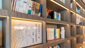 A bookshelf with books and decorative items. - HanTing Hotel (Qinhuangdao Development Zone Yanshan University) (Qinhuangdao)