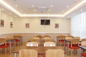A conference room with tables and chairs, a flat-screen TV, and a tiled accent wall. - Homeinn Hotel (Shanghai Pudong Xinchang Industrial Park Tanzhi Town) (Shanghai)