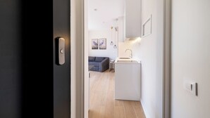 Eine moderne Küche mit Einbauofen, einer kleinen Spüle und Pendelleuchten.