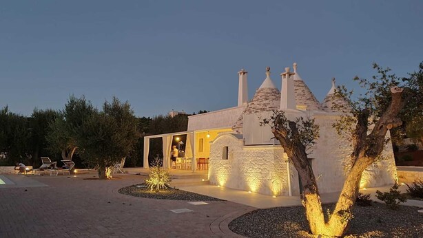 A modern villa with a stone facade, a swimming pool, and outdoor seating. - Trullo Sogni Di Pietra - Ostuni (Ostuni)