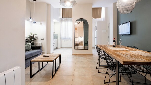 A modern kitchen with a wooden dining table, black chairs, and pendant lights. - Bebarceloner Sants Estudios A6 (Barcelona)