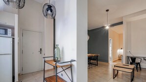 A modern kitchen with a built-in microwave, a wooden table with metal legs, and a hanging light fixture. - Bebarceloner Sants Estudios A6 (Barcelona)
