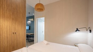 A hotel room with a bed, a wooden wardrobe, a dining area, and a television. - Bebarceloner Sants Estudios A6 (Barcelona)