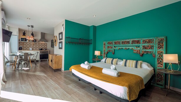 A modern hotel room with a large bed, a dining area, and a kitchen. - Jaume Atico 509 - Studio Apartment, Sleeps 2 (Barcelona)