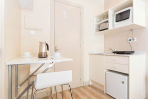 A small kitchenette with a coffee maker, a microwave, and a refrigerator.
