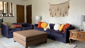 A living room with two sofas, a coffee table, and a wooden cabinet. - Charming, vintage 3-bedroom house in Arvada with AC (Arvada)