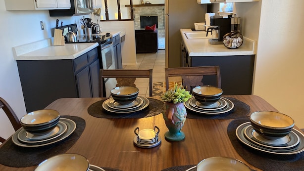 A dining area with a wooden table set for six, surrounded by chairs. - Charming, vintage 3-bedroom house in Arvada with AC (Arvada)