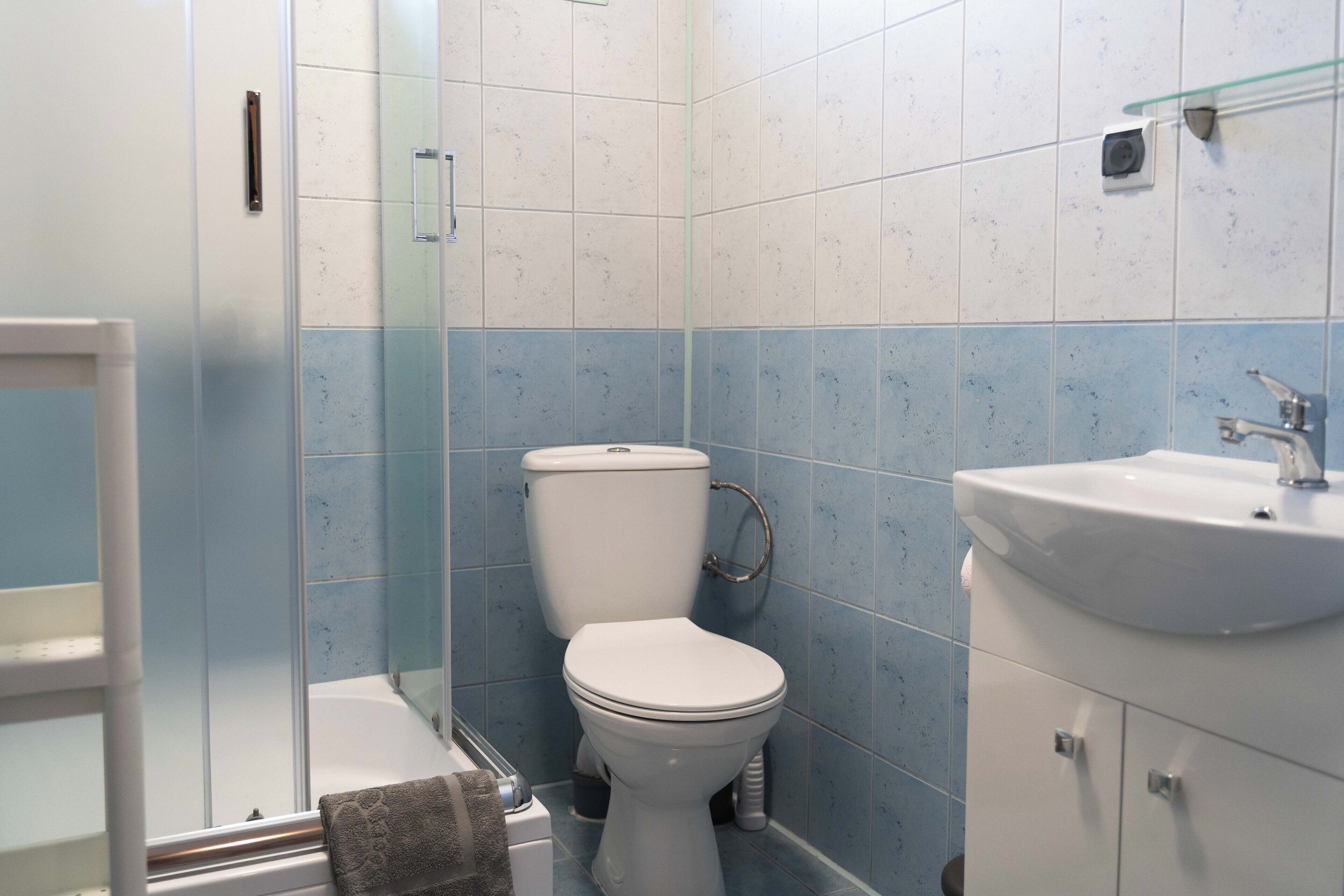 A bathroom with a toilet, a sink, and a glass shower enclosure.