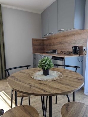 Apartamento Deluxe | Cocina privada | Frigorífico grande, placa de cocina, hervidor eléctrico y trona infantil