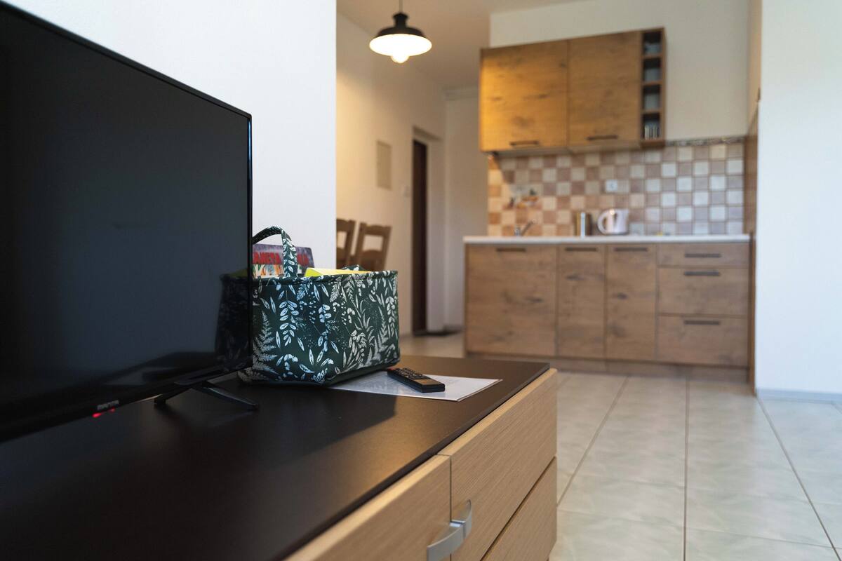 A modern kitchen with wooden cabinets and a tiled backsplash.