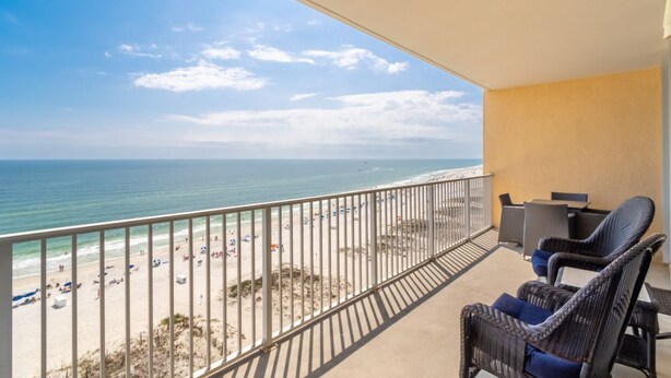 Un balcon avec vue sur la plage et l’océan.
