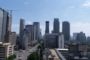 A cityscape with high-rise buildings, a clear sky, and a busy street.