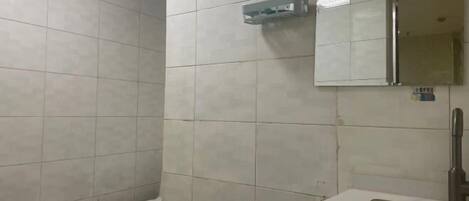 A bathroom with a toilet, a sink, and a mirror.