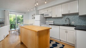 Eine moderne Küche mit weißen Schränken, einer Holzinsel und einer blau gefliesten Spritzschutzwand.