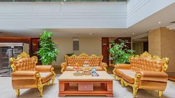 A luxurious lobby with a high ceiling, a central coffee table, and two sofas.