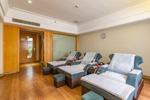 A room with three massage therapy chairs, a wooden door, and a wall clock. - M Hotel (Dongguan Haichao) (Dongguan)